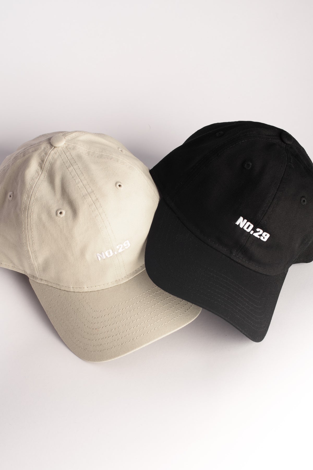 NO.29 dad cap in black and khaki, featuring minimalist embroidered branding. A classic, versatile accessory designed for effortless everyday wear.